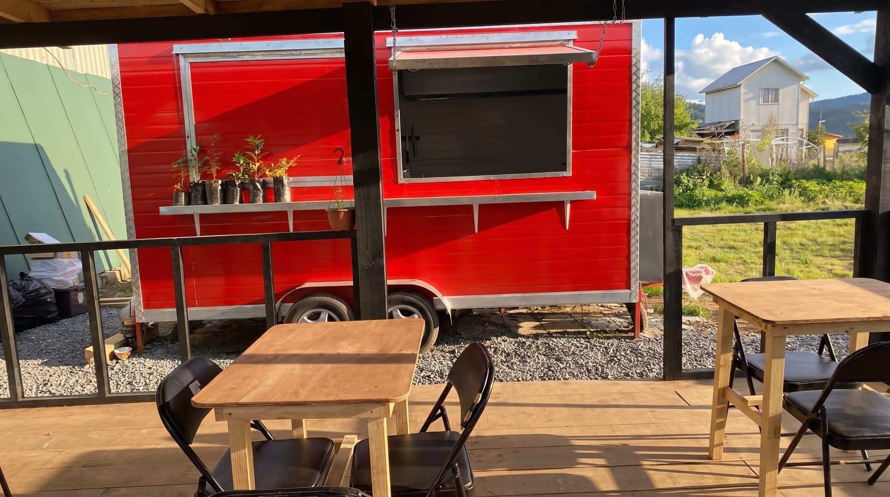 Carro rojo de Espacio Urbano con mesas bajo la terraza techada