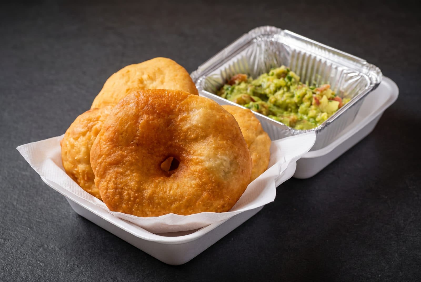 Sopaipillas recién fritas junto a un pocillo de guacamole